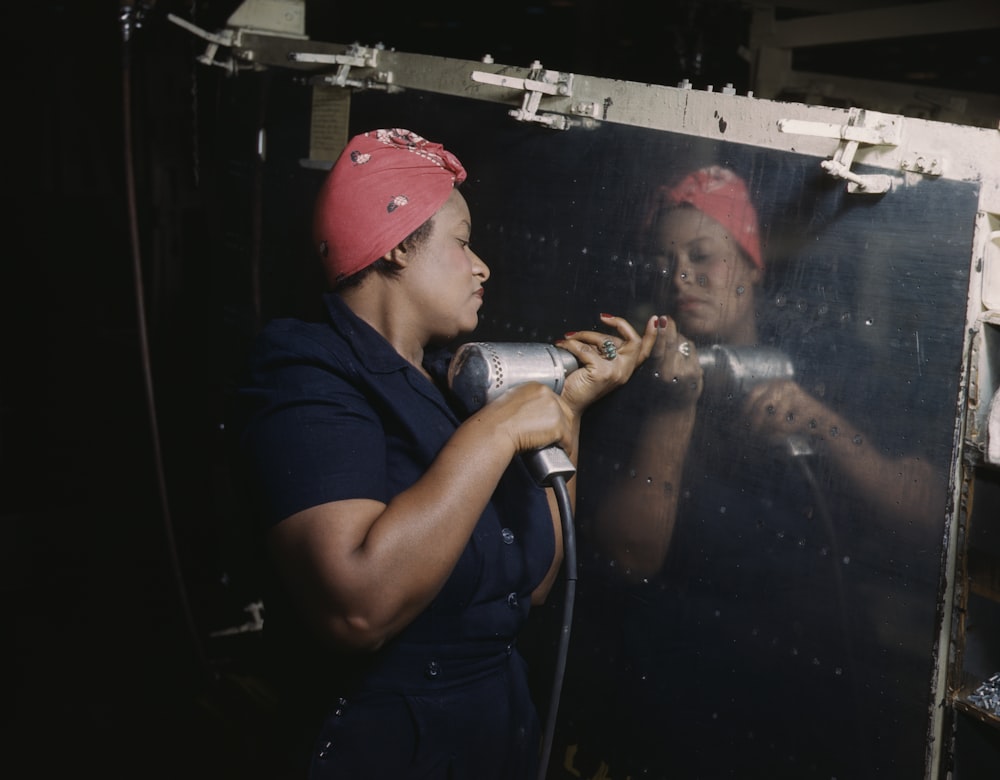 Operating a hand drill at Vultee-Nashville, woman is working on a "Vengeance" dive bomber, Tennessee