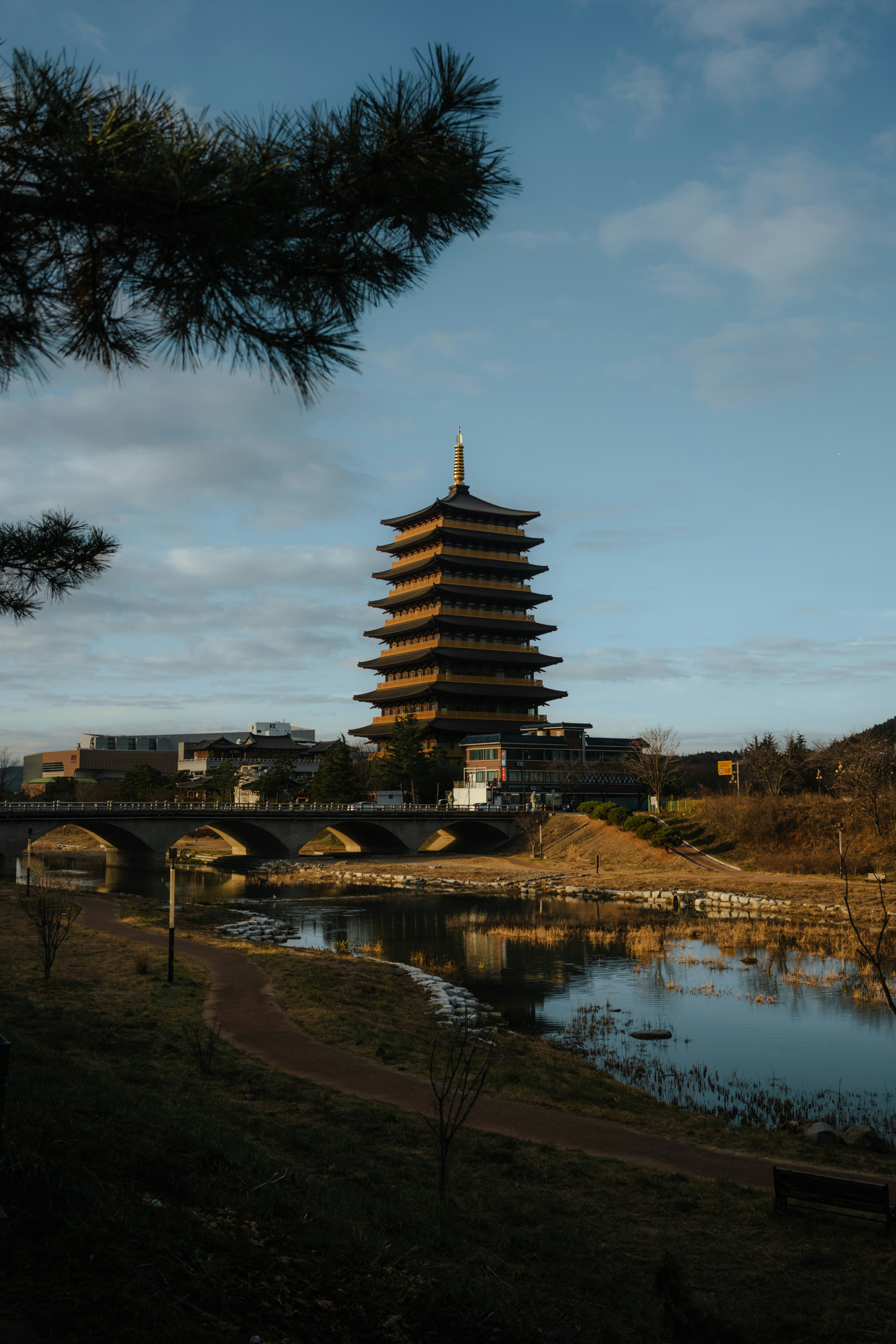 un'alta torre seduta accanto a un fiume sotto un cielo blu