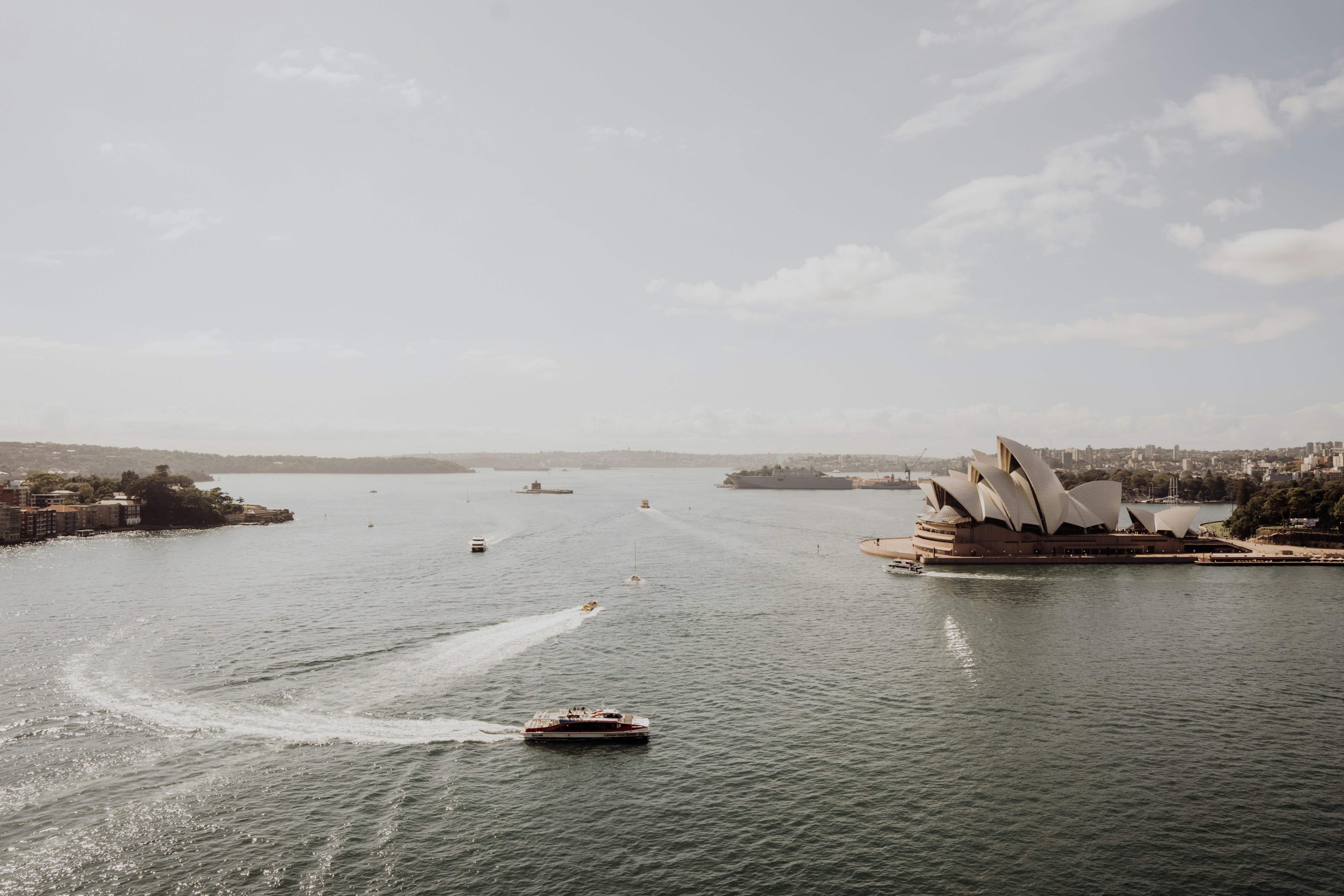 a boat traveling down a river next to a city, 