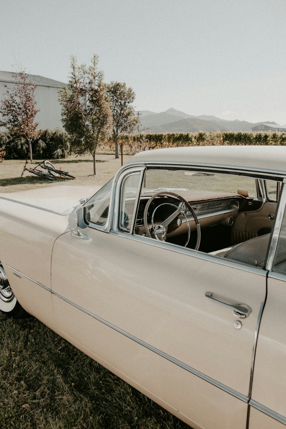 an old car parked in a field with grass