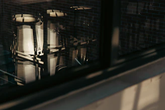 Set of metal and wood stools arranged in a dimly lit corner with atmospheric shadows