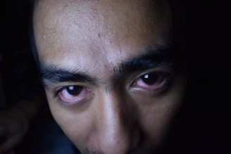 Close-up of a dermatologist examining a patient's skin under a bright clinic light.