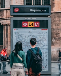 A smiling couple reviewing transportation maps and schedules together in a cozy café.