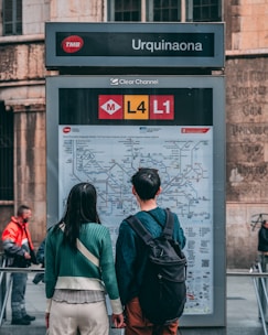 A smiling couple reviewing transportation maps and schedules together in a cozy café.