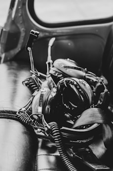 A sleek headset resting on a wooden table with aviation charts in the background