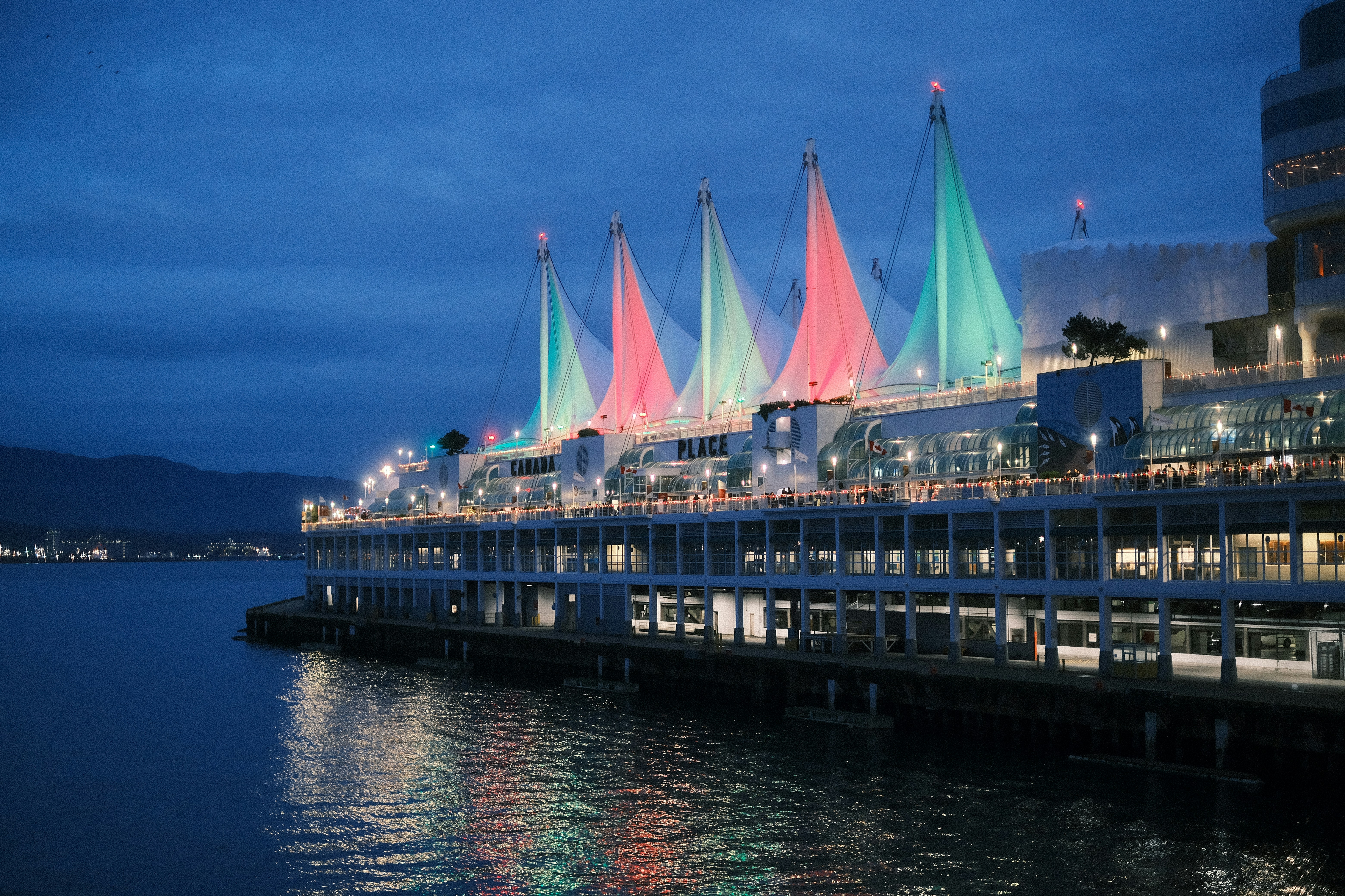 a pier that has a bunch of colorful umbrellas on it