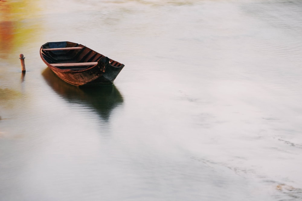 un petit bateau flottant au-dessus d’un plan d’eau