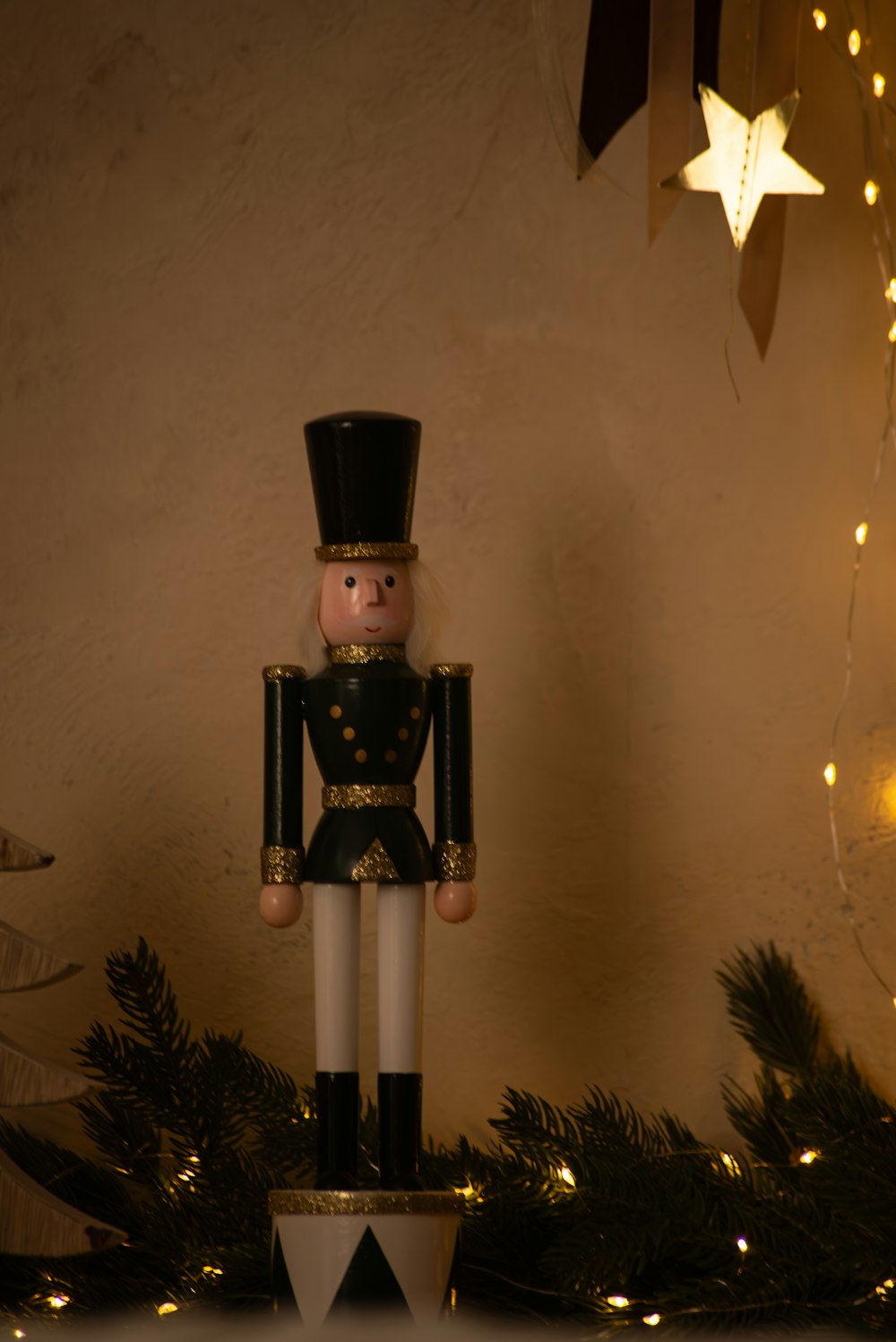 a nutcracker is standing on top of a christmas tree