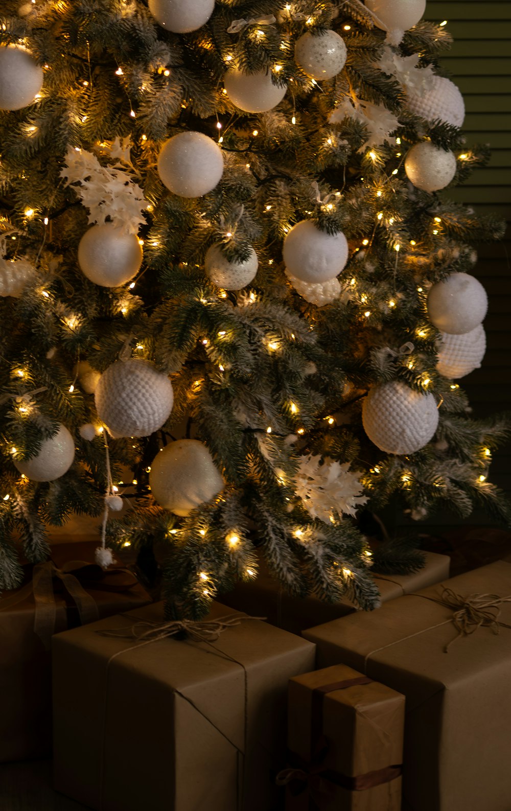 Un árbol de Navidad decorado con regalos debajo de él