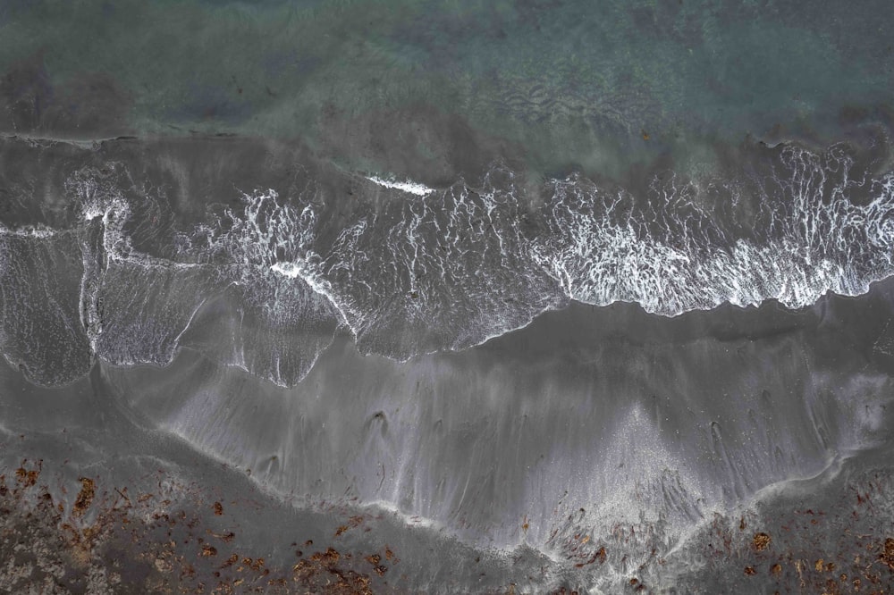 an aerial view of a beach with waves