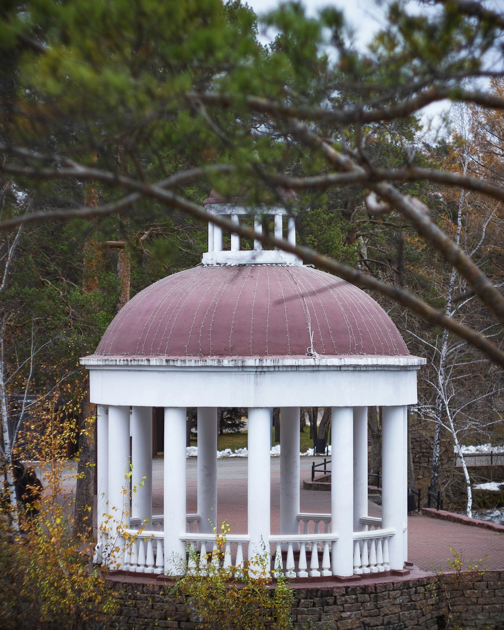 a gazebo in a park surrounded by trees