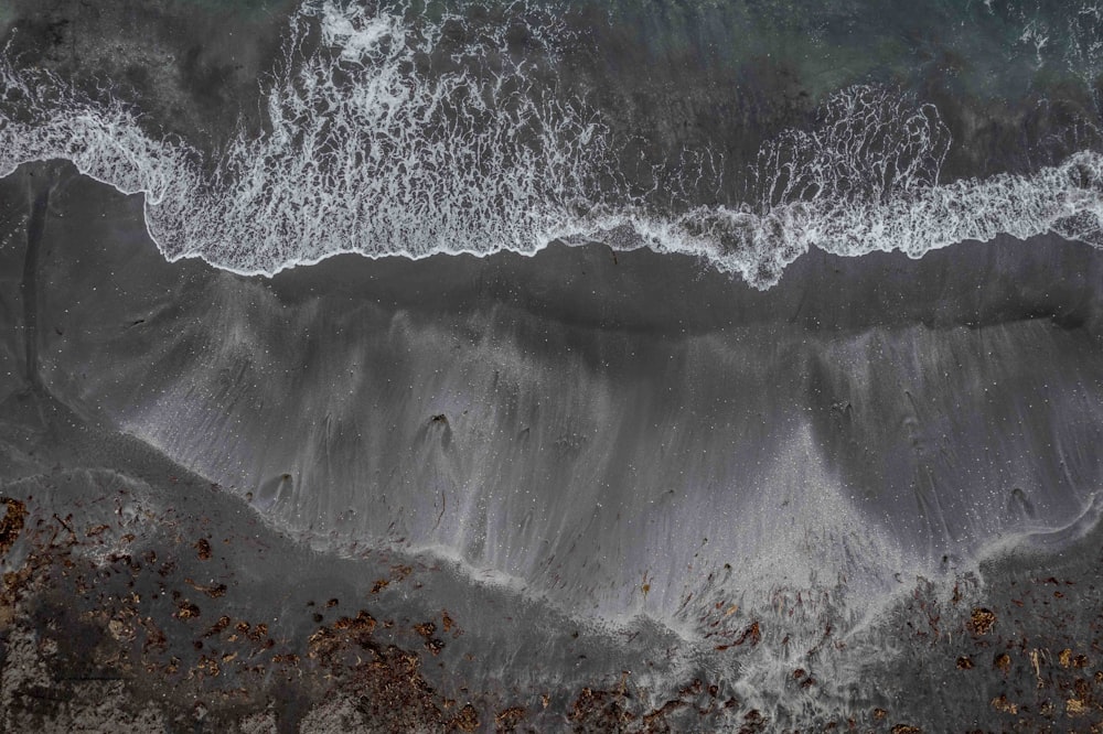 an aerial view of a beach with waves crashing on it