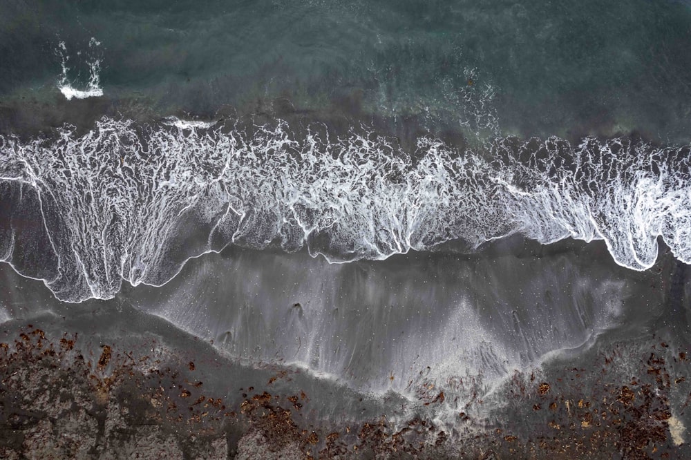 an aerial view of a beach with waves crashing on it