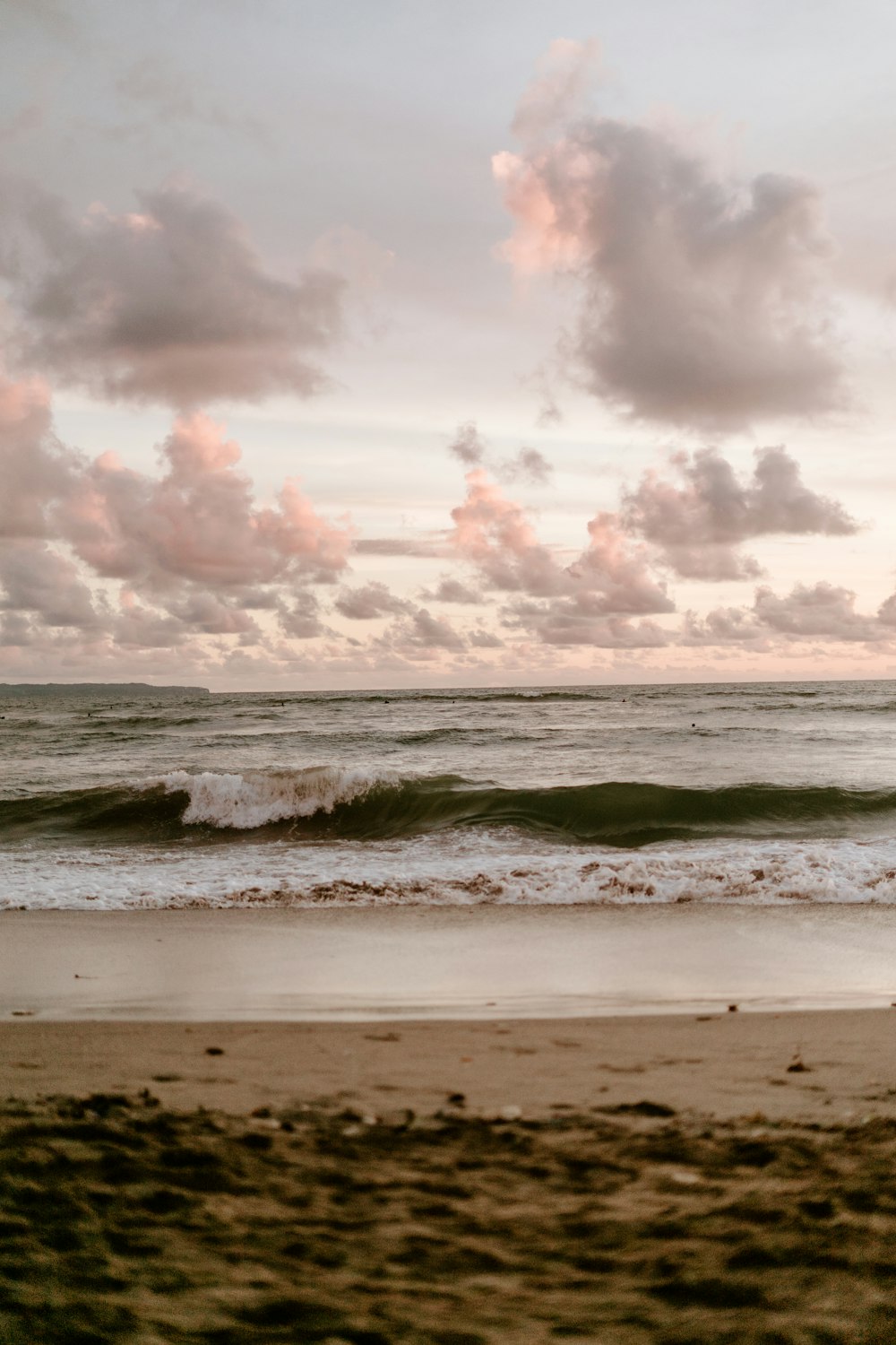 a person riding a surfboard on top of a sandy beach