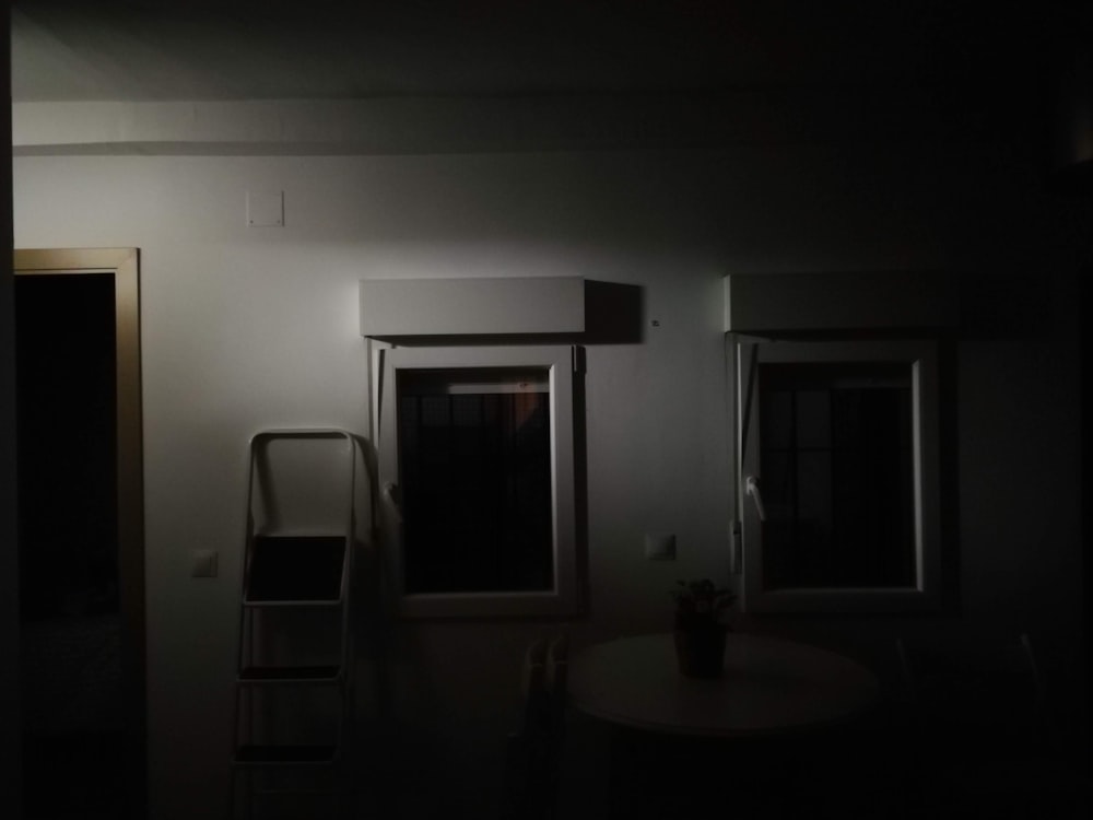 a dark room with a chair and a table