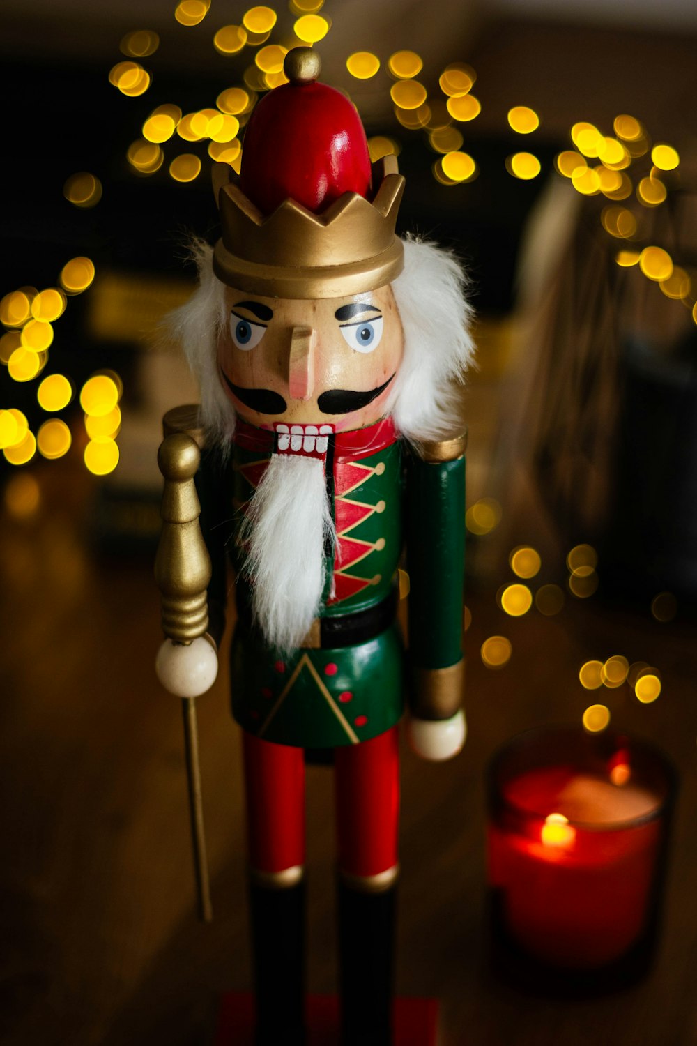 a nutcracker is standing next to a candle