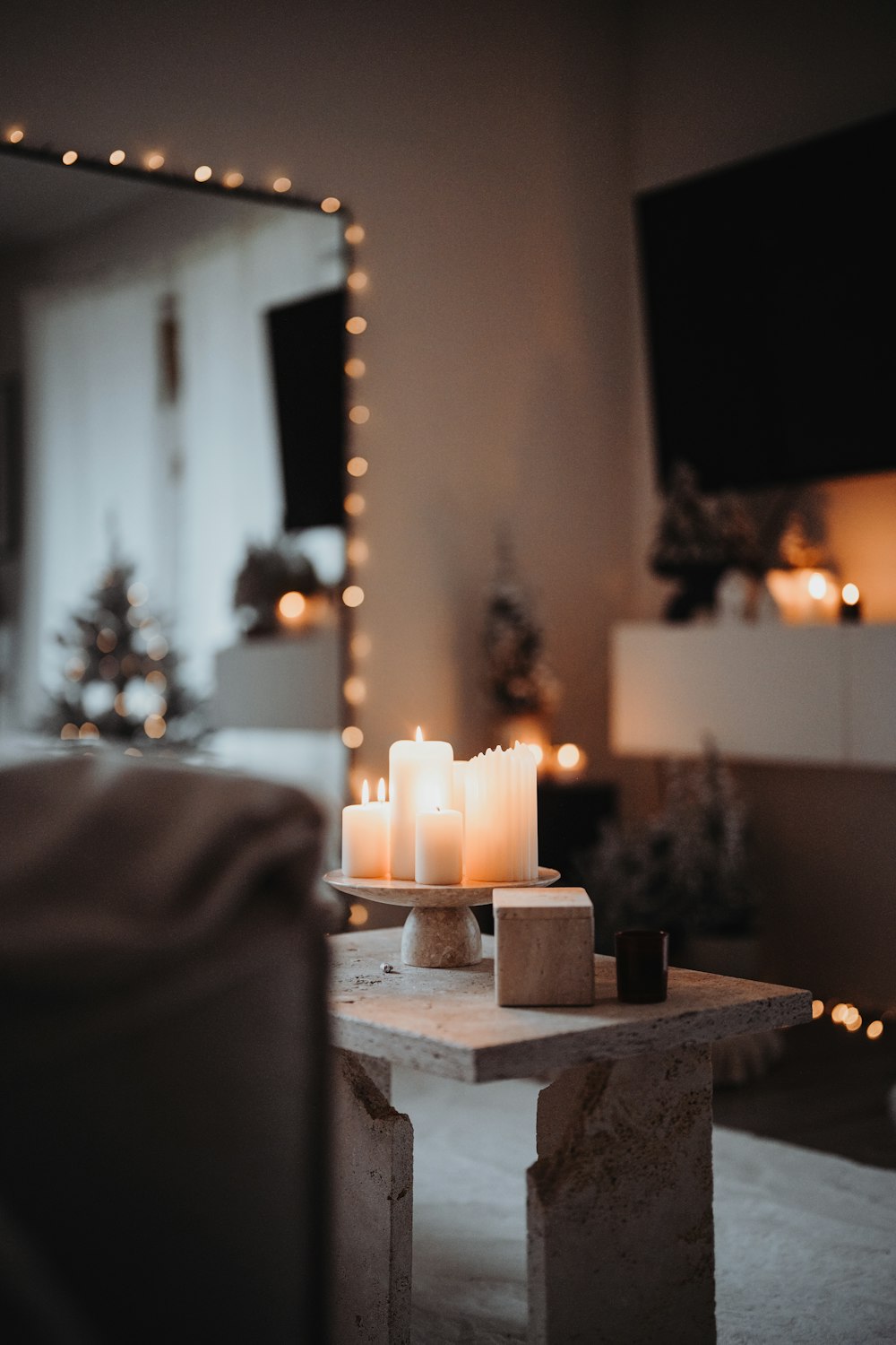 eine brennende Kerze auf einem Tisch in einem Wohnzimmer