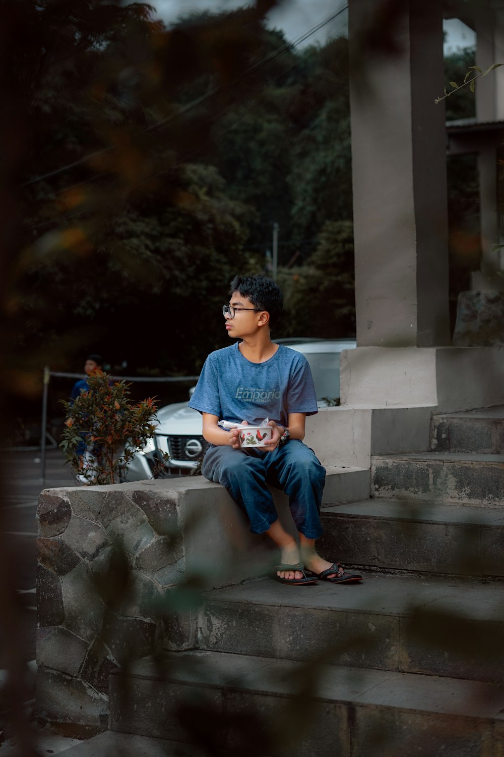 a young man sitting on the steps of a building