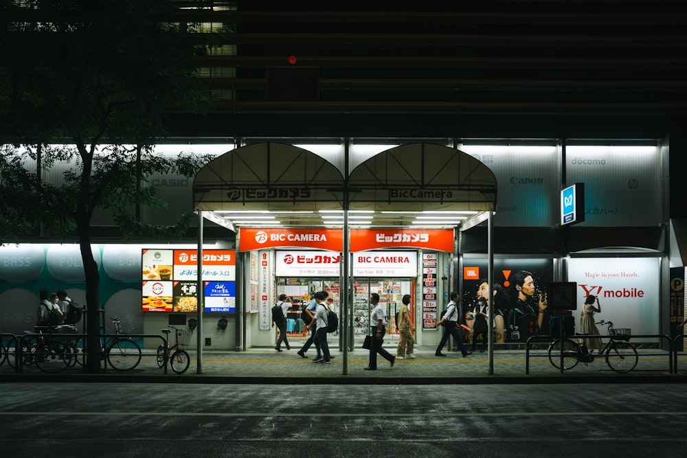 a group of people walking down a street at night