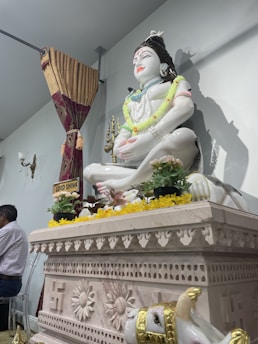 A serene marble idol displayed against an earthy backdrop, ready for export.