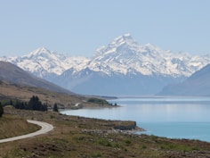 a scenic view of a mountain range with a lake in the foreground