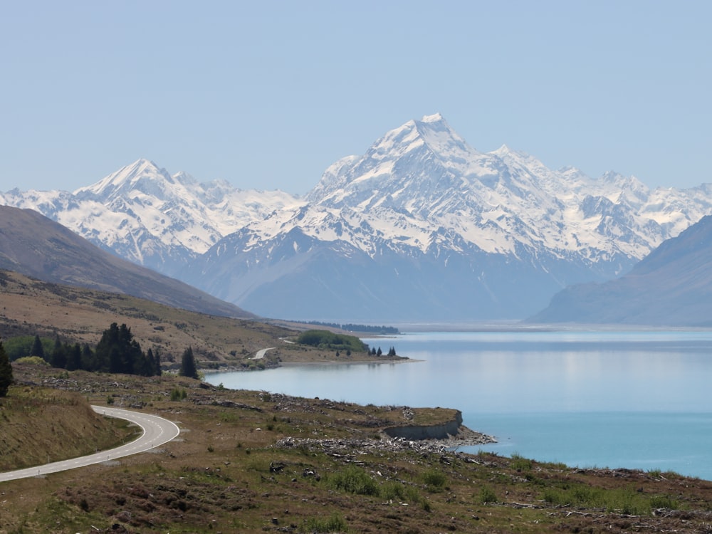 a scenic view of a mountain range with a lake in the foreground