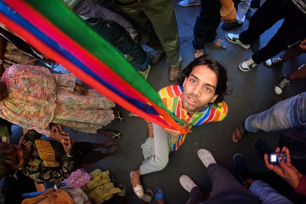 a man holding a rainbow flag in front of a group of people