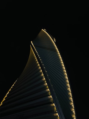 A sleek, aerodynamically designed vertipad glowing softly at dusk, surrounded by city skyline.