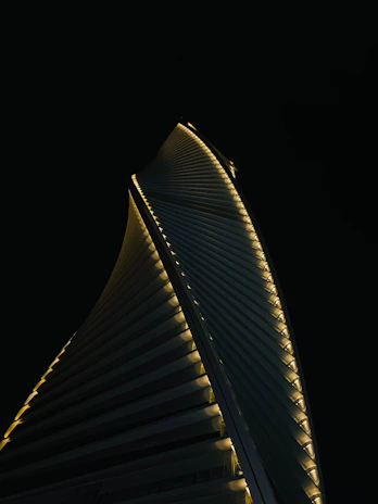 A sleek skyscraper with vertical lines glowing against a twilight sky, symbolizing strength and elegance.