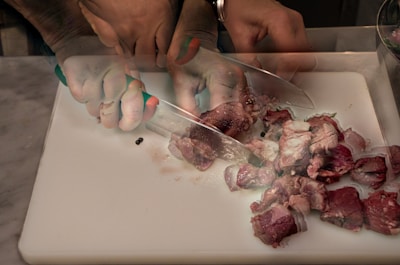 A chef’s hand gripping a comfortable handle while chopping meat with precision.