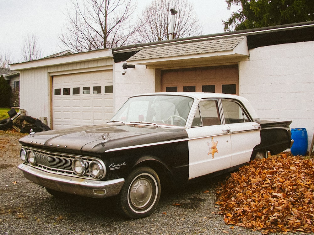 a black and white police car parked in front of a garage