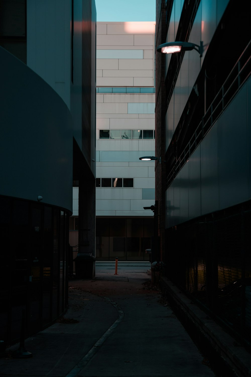 Un callejón oscuro con un edificio al fondo