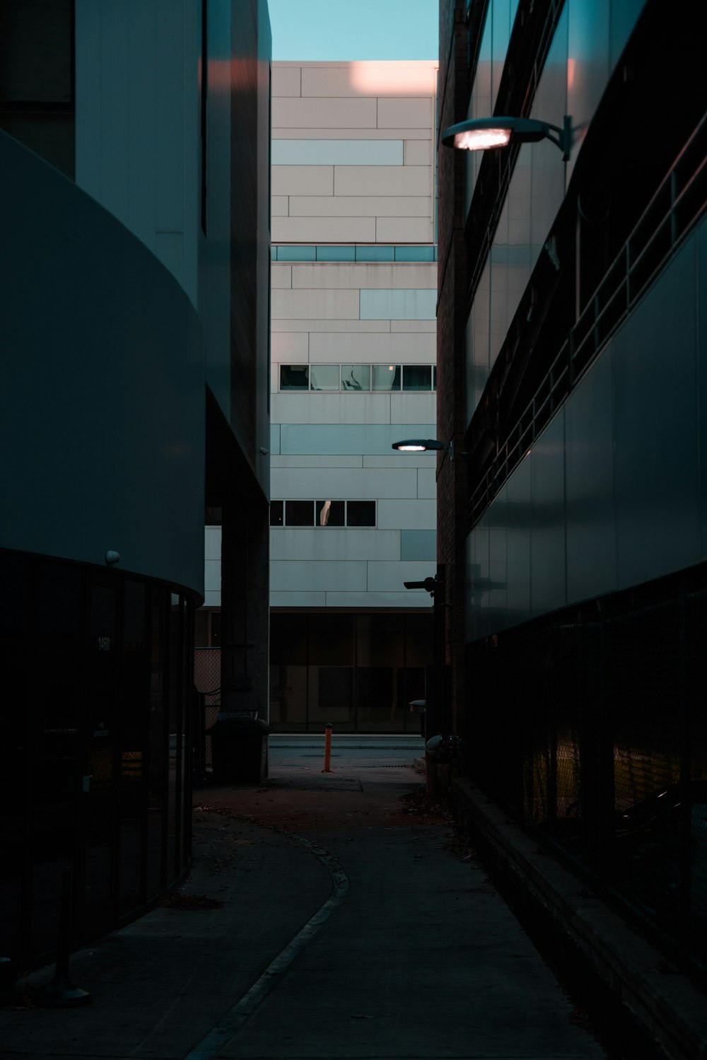 eine dunkle Gasse mit einem Gebäude im Hintergrund