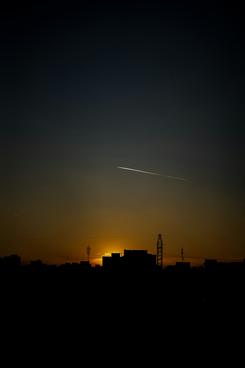 夕暮れ時に街の上空を飛ぶ飛行機