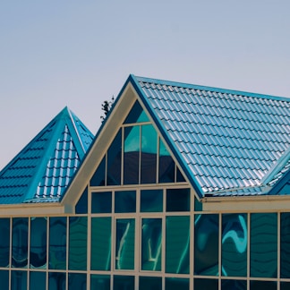 a building with a blue roof and a clock on the side of it