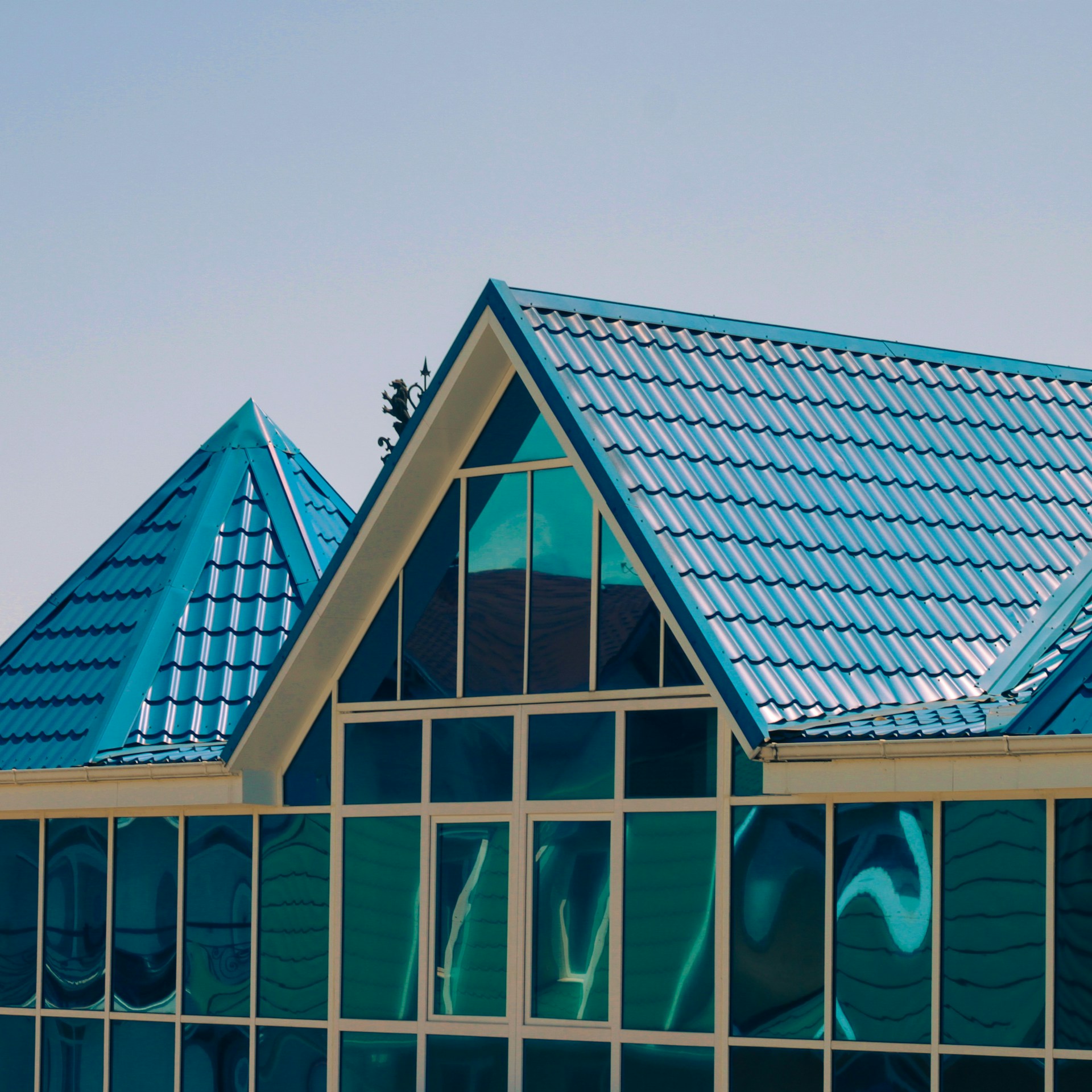 a building with a blue roof and a clock on the side of it