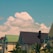 A serene view of a residential plot with lush greenery and clear blue skies.