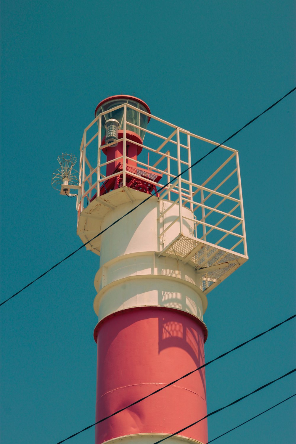 a red and white lighthouse with a blue sky in the background