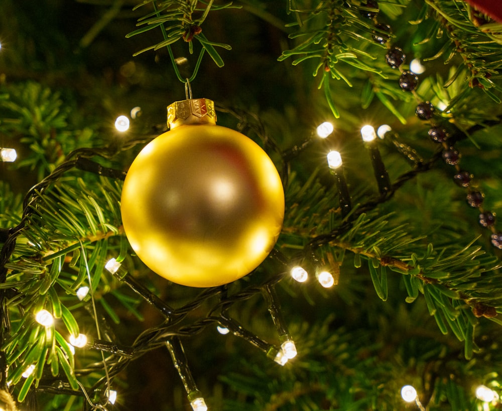 a yellow ornament hanging from a christmas tree