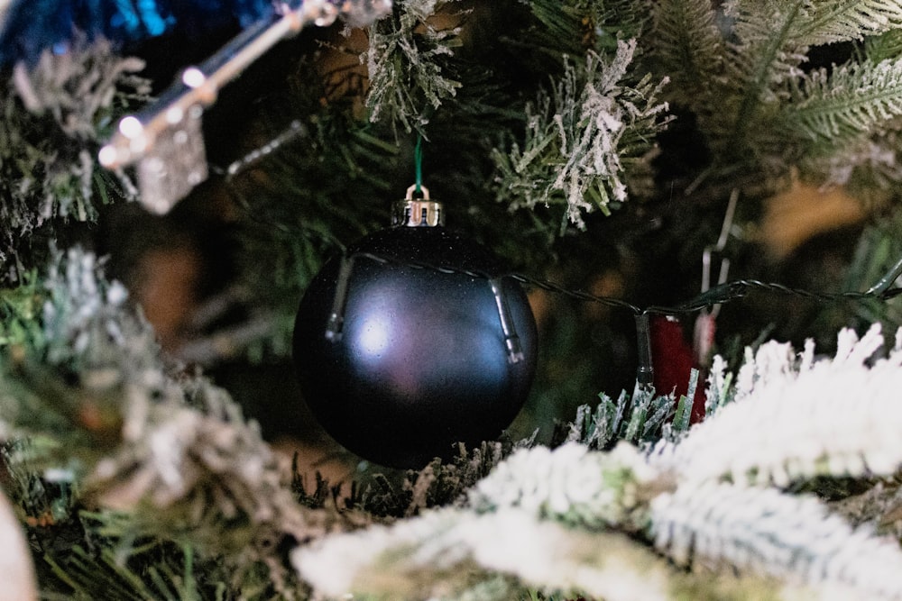 a black ornament hanging from a christmas tree