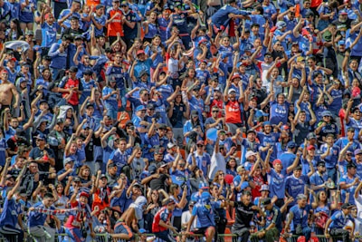 A group of enthusiastic fans cheering at an esports event.