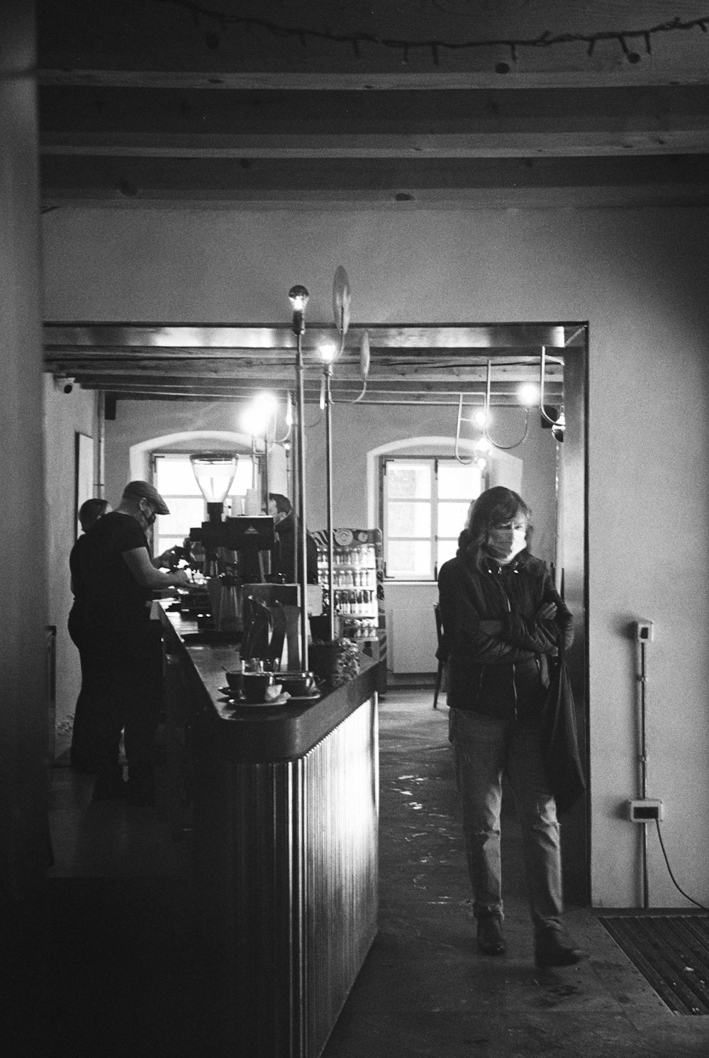 a man walking down a hallway next to a bar