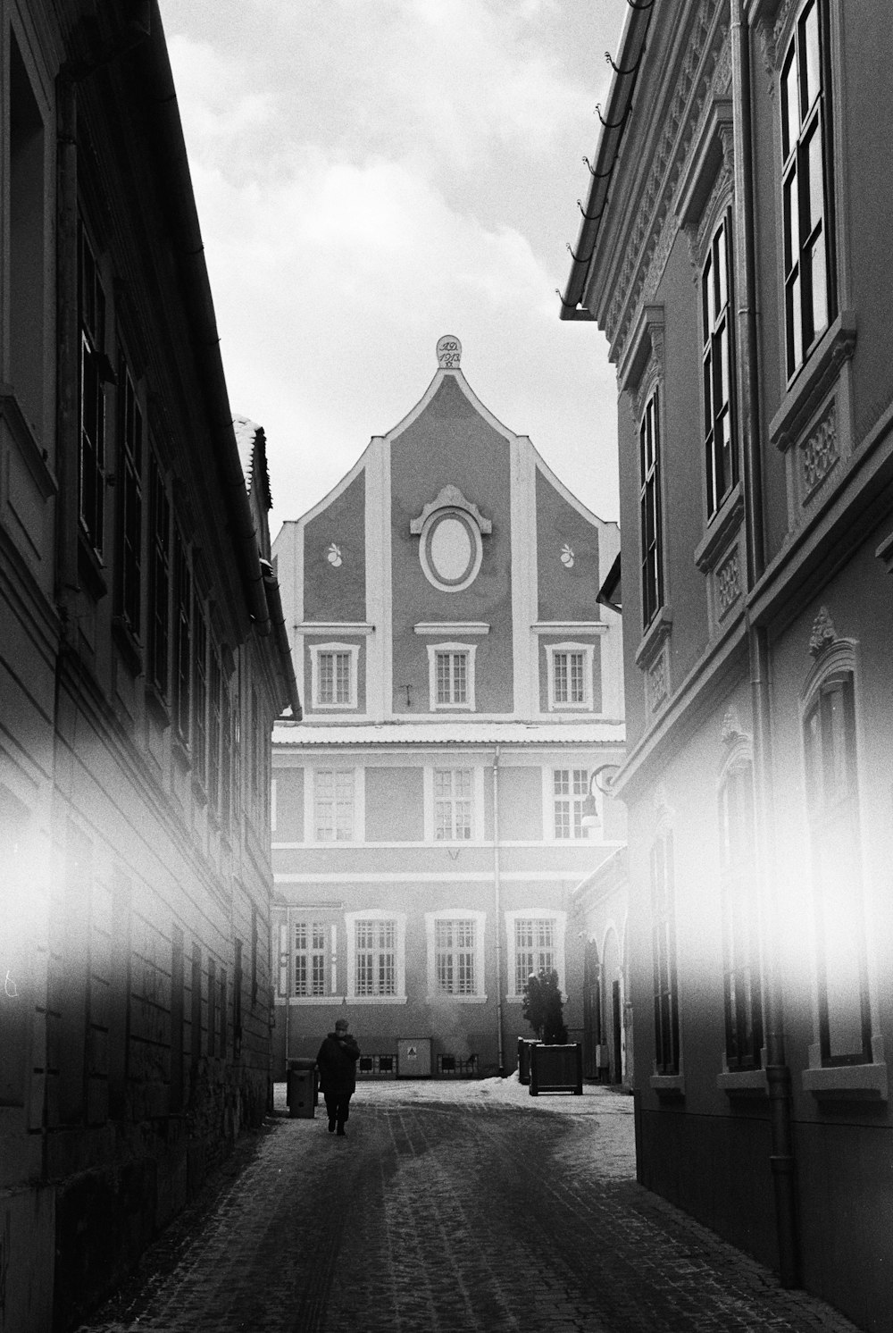 a black and white photo of a person walking down a street