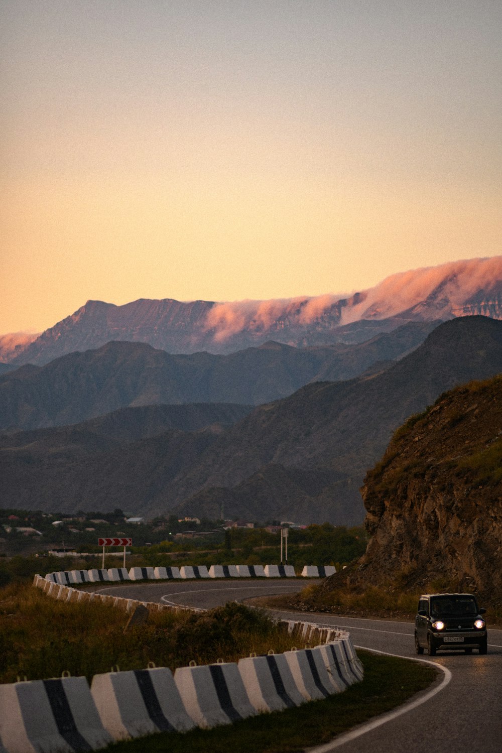 a car driving down a road with mountains in the background