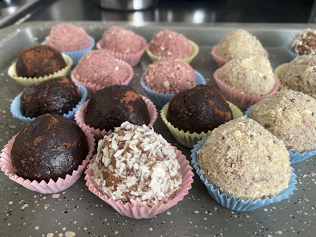 Close-up of assorted gourmet brigadeiros in decorative paper cups with colorful sprinkles
