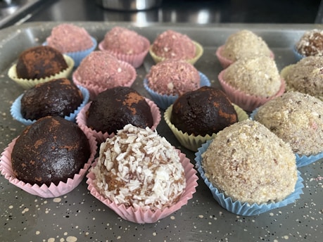 Close-up of colorful brigadeiros and beijinhos arranged on a festive platter.