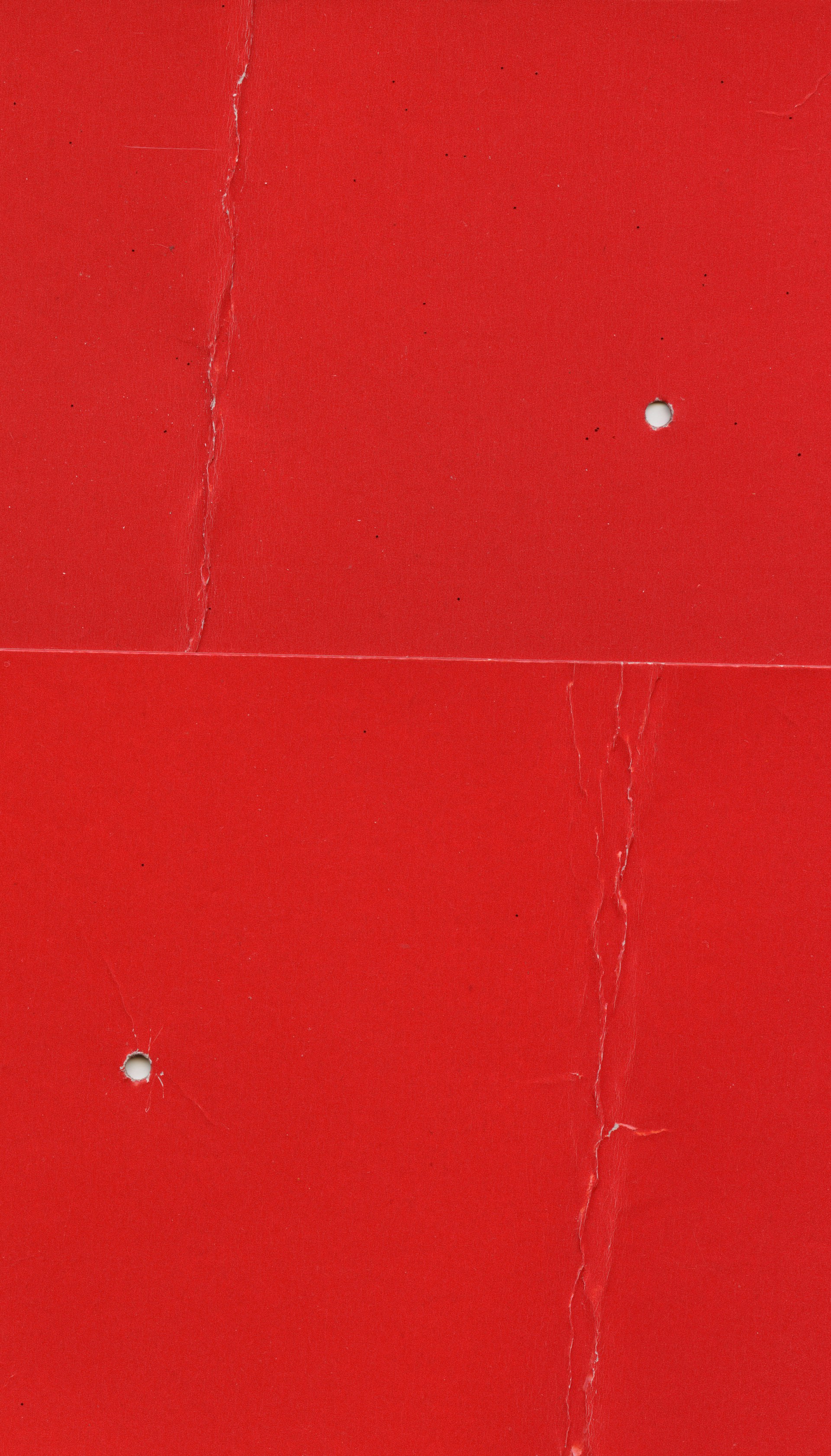 a close up of a red wall with holes in it