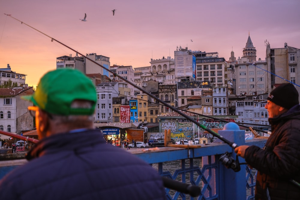 a couple of men standing next to each other on a bridge