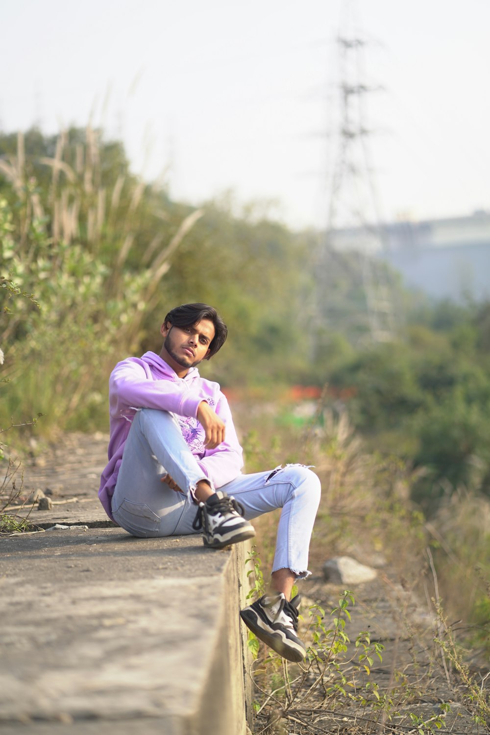 a woman sitting on the edge of a cement wall