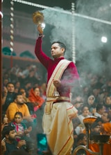 a man in a red and white outfit holding a candle